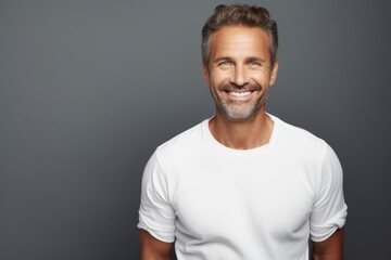 Obraz premium Portrait of a grinning man in his 40s sporting a long-sleeved thermal undershirt isolated in soft gray background