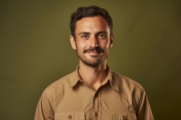 Fototapeta premium Portrait of a glad man in his 30s sporting a breathable hiking shirt isolated in soft brown background