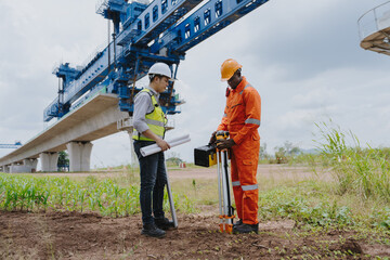 Surveying engineers take measurements with theodolite instruments at construction sites. Surveyors or surveyors view construction sites or conduct safety inspections.