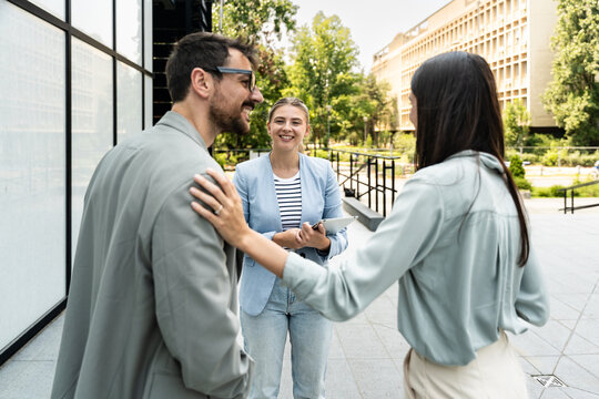 Group of young successful professional business people standing outside office building discussing opportunities and prepare for corporate staff meeting of employees. Occupational and employee concept