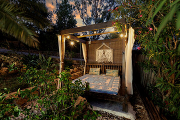 Garden with wooden gazebo in the evening. The sky at sunset, a place of privacy and relaxation.