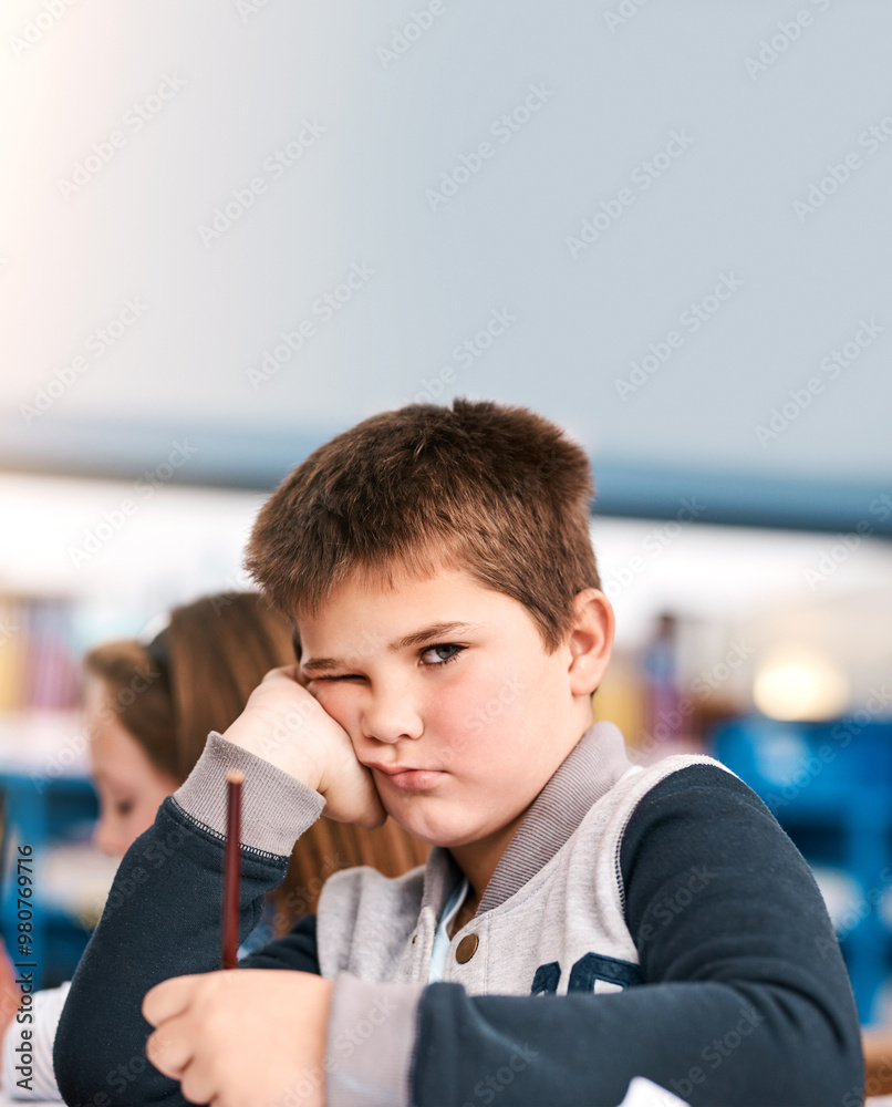 Poster bored, education and portrait of boy student in classroom of school for child development or study. 
