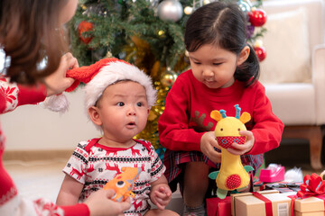 Parents and their two children are dressed in Christmas outfits to celebrate the Christmas holiday at home