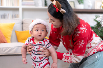 Little child with parents joyful moment celebrating together at home during the Christmas season