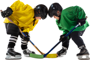 Two young hockey players, boys one in yellow and green uniform, face off with sticks hover near puck, ready for action isolated on transparent background. Concept of sport, childhood, active lifestyle
