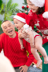 Little child with a joyful moment for a large family celebrating together at home during the Christmas season