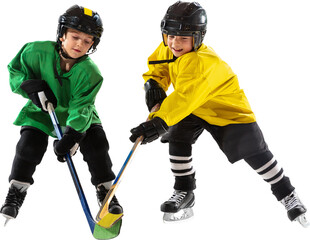Two kids in hockey gear, in green yellow, battling for control of puck, training with focus...