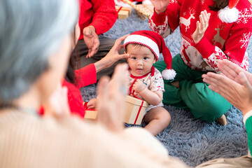 Obraz premium Little child with a joyful moment for a large family celebrating together at home during the Christmas season