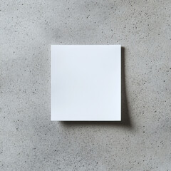 A blank square note on textured concrete background, perfect for messages or reminders. This minimalist design emphasizes simplicity and functionality