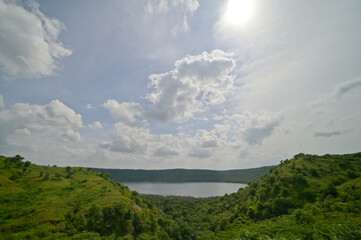 Faraway view of Lonar crater lake under cloudy skies, Maharashtra, India.