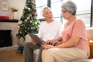 Obraz premium Grandfather and grandmother are reviewing the expenses and the food menu to host their children and grandchildren during the Christmas holiday at home