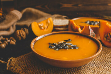 Pumpkin soup on black background, cozy autumn