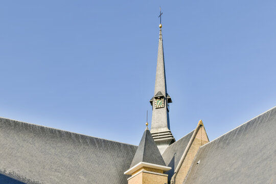 Church Spire Reaching Skyward Against Blue Background