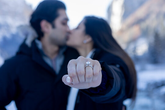 Indian couple celebrating engagement in snowy landscape