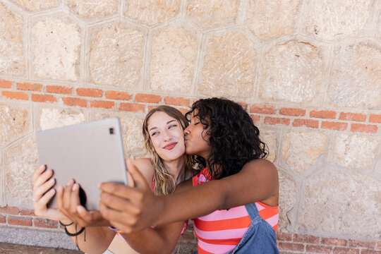 Lesbian couple enjoying a selfie moment in outdoor setting