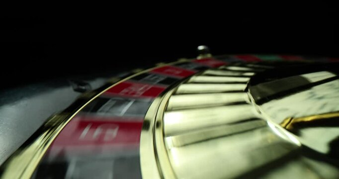 Metal ball is spinning on roulette wheel in casino closeup. Gambling and casino