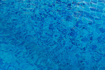 Blue water surface viewed from above in outdoor sea, sun reflection, dimply. Surface Abstract Background.