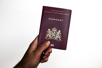 Hand holding Dutch passport for international travel