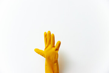 Person in yellow rubber glove on white background reaching out to side of screen