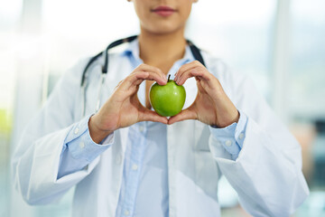 Hands, doctor and apple in hospital, healthcare and medical professional with nutrition, heart and...