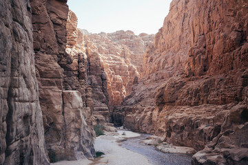 Wadi Mujib trail beautiful scenery hike Jordan. Wadi Al Mujib Canyon in Wadi Mujib Nature Biosphere Reserve. Sheer cliffs of enormous height are polished by water of Wadi Mujib River.