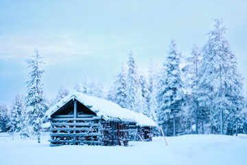 Wooden Cabin Storage for Firewood Covered with Snow in the Winter Forest