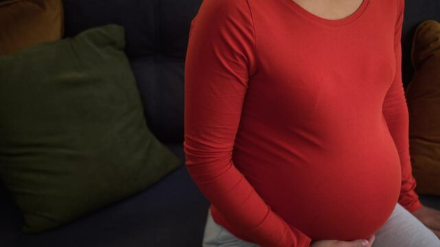 Stressed upset sad frustrated ill thinking depressed mother pregnant woman African American unhealthy girl female home couch pregnancy problem touch big belly tummy child kick discomfort ache breakup