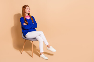 Full size photo of nice young woman sit chair look empty space wear pullover isolated on beige...