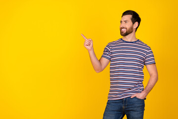 Portrait of satisfied guy with bristle wear striped t-shirt look directing at offer empty space...