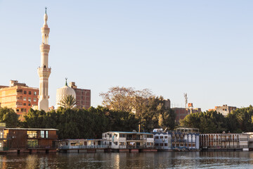 Cairo, Egypt - 8 February 2022: houseboats and a mosque on the Nile in Zamalek district in golden hour
