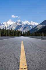 Straight asphalt highway road and green forest with snow mountain natural landscape under blue sky. car background.