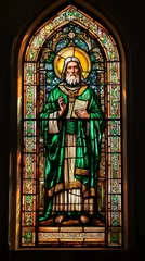 Stained glass of Saint Patrick in traditional green robe inside a church