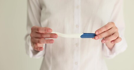 Young woman holds positive or negative pregnancy test result in hands. Treatment of female infertility and concept of in vitro fertilization