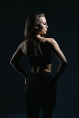 Fototapeta premium Elegant silhouette of a woman posing confidently in low light