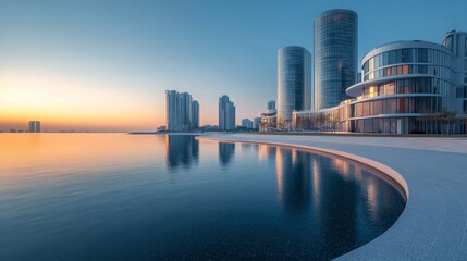 Obraz premium Modern Architecture Reflecting in Calm Water at Sunset