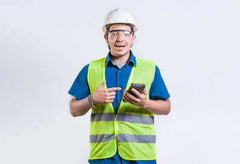 Smiling engineer holding phone and looking at camera isolated. Latin male builder engineer using phone isolated