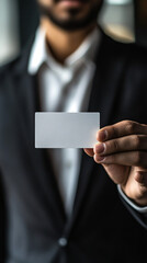 Confident businessman in suit holding blank business card for personalized design in modern office setting