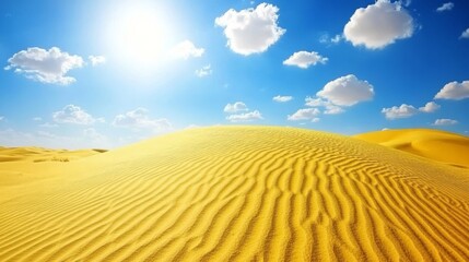 Beautiful sand dunes under a bright sun with scattered clouds in a clear blue sky on a sunny day.