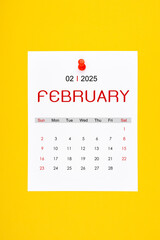 February 2025 calendar page with push pin on yellow background.
