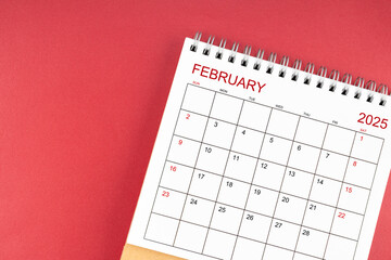 February 2025 desk calendar on red background.