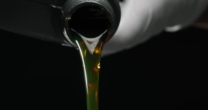 Auto mechanic in gloves pours engine oil into engine. Quality engine oil