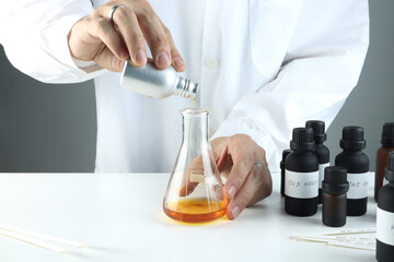 chemical beaker , flask is on white table with blotting paper , fragrance bottle and essential oil...