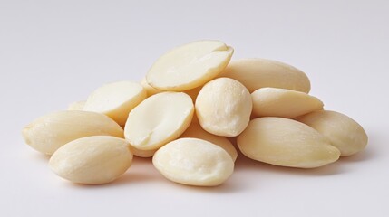 A close-up of a handful of blanched almonds on a white background, highlighting their smooth surface and pale color in a clean, minimalist setting.