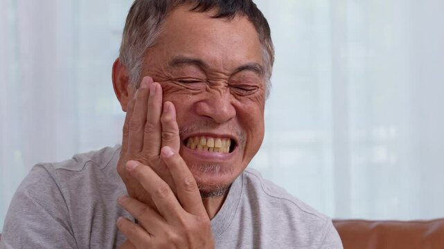 Asia old senior men suffering from severe toothache, holding him cheek and suffering strong dental pain on white background, tooth decay, tooth sensitivity, oral health care concept.