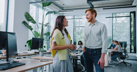 Satisfied mixed-raced workers talking with each other during free time at work. Pretty woman...