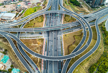 Aerial view of complex highway interchange surrounding lush greenery in daylight