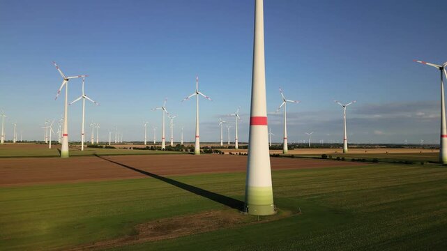 Aerial, sich drehende Windr&auml;der eines grossen Windparks im Abendlicht. Landschaft in Norddeutschland mit gro&szlig;en Windr&auml;dern die Energy in nachhaltiger Form erzeugen