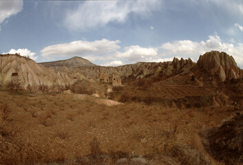 Barren Landscape with Rocky Formations Under Cloudy Sky