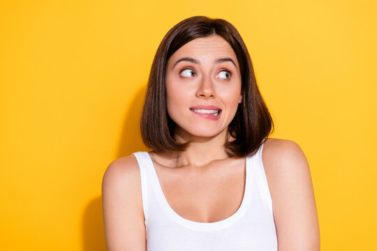 Photo portrait of attractive young girl look empty space confused wear trendy white outfit isolated on yellow color background