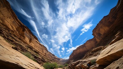 Fototapeta premium Dramatic Sandstone Canyoneering Adventure with Wispy Clouds Overhead in Remote Desert Landscape